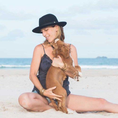 lady hugging a puppy on the beach