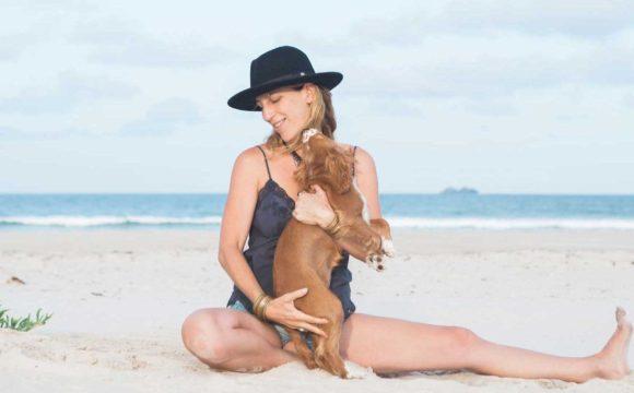 lady hugging a puppy on the beach