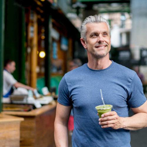 gentleman smiling with a healthy smoothie in hand