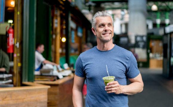 gentleman smiling with a healthy smoothie in hand